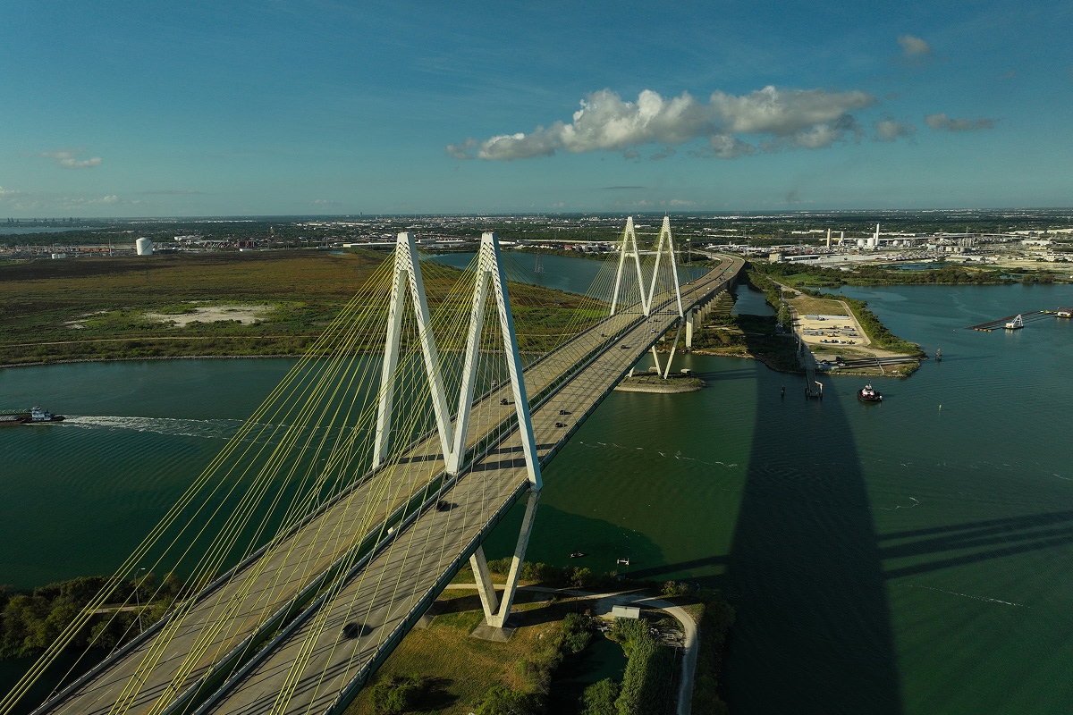 Aerial view of the Houston Ship Channel with a cable-stayed bridge and industrial facilities along the waterway